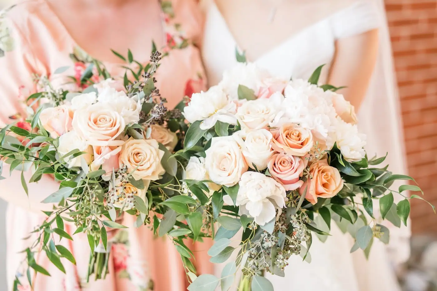 Peach, blush and white bridal bouquets with roses, ranunculus and greenery, made at Flowers – Wayne Jones